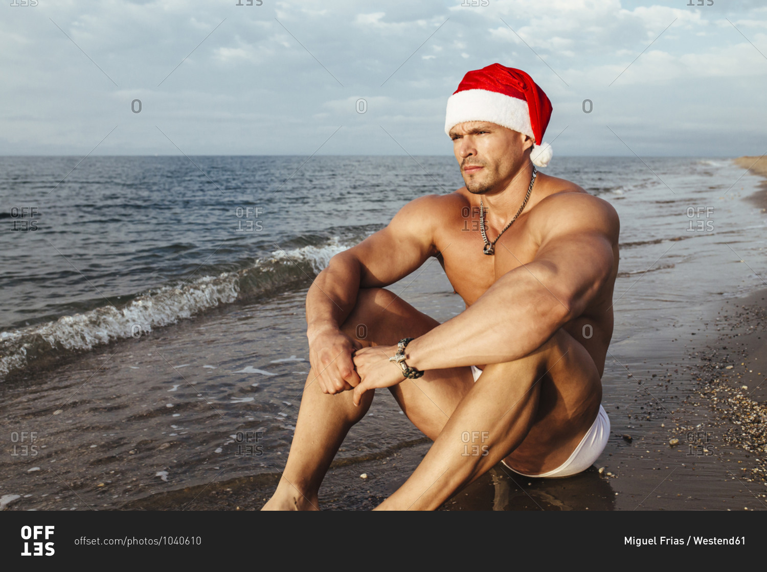 Premium Photo  Shirtless macho man in santa hat holding gifts