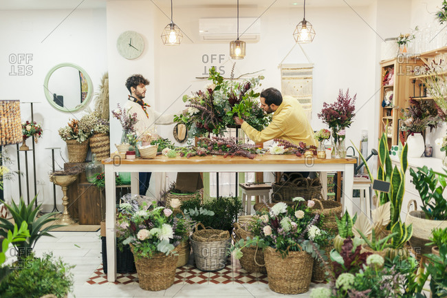 Florists arranging flower while standing at flower shop