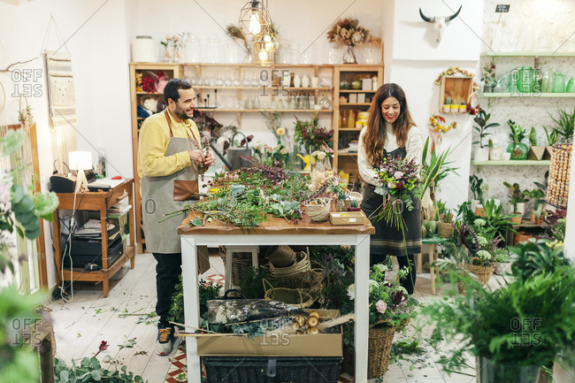 Man and woman working while standing at flower shop