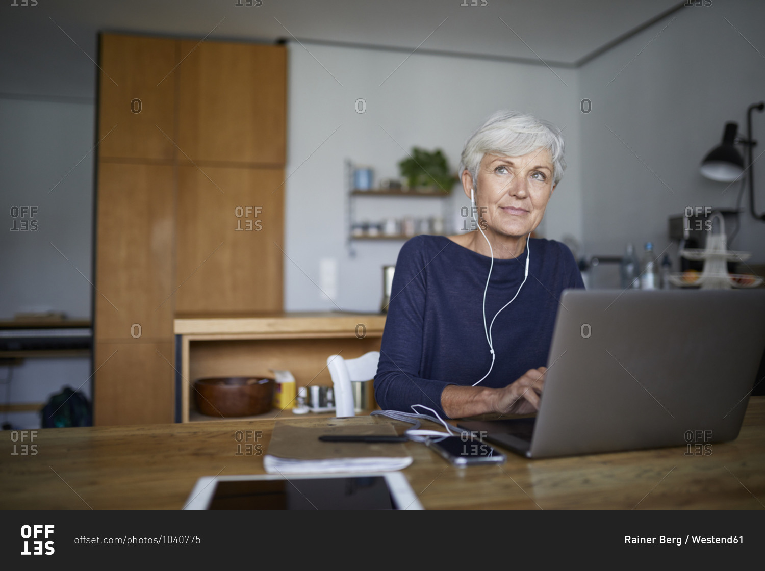 Senior woman working on laptop while sitting at home