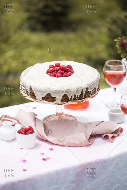 Carrot cake with raspberries on an outdoor table