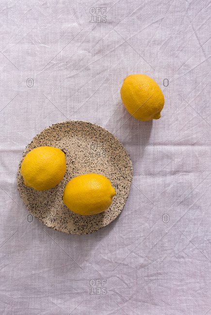 Top down view of fresh lemons on a white tablecloth