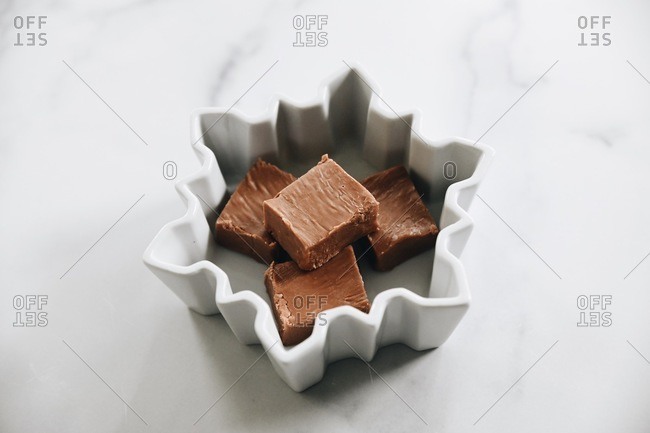 Top down view of fudge squares in a white snowflake shaped dish