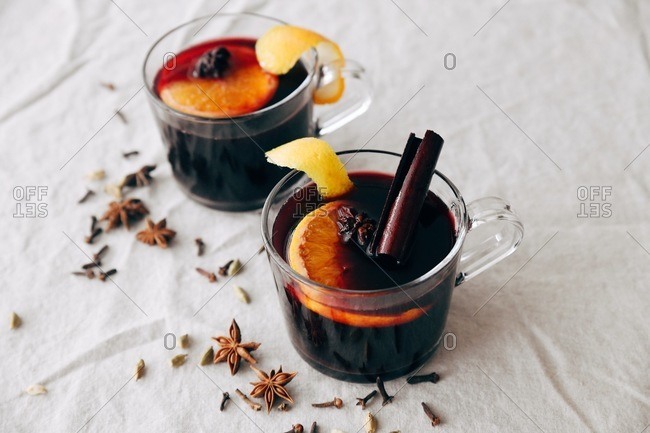 Spiced citrus mulled wine on white linen surface