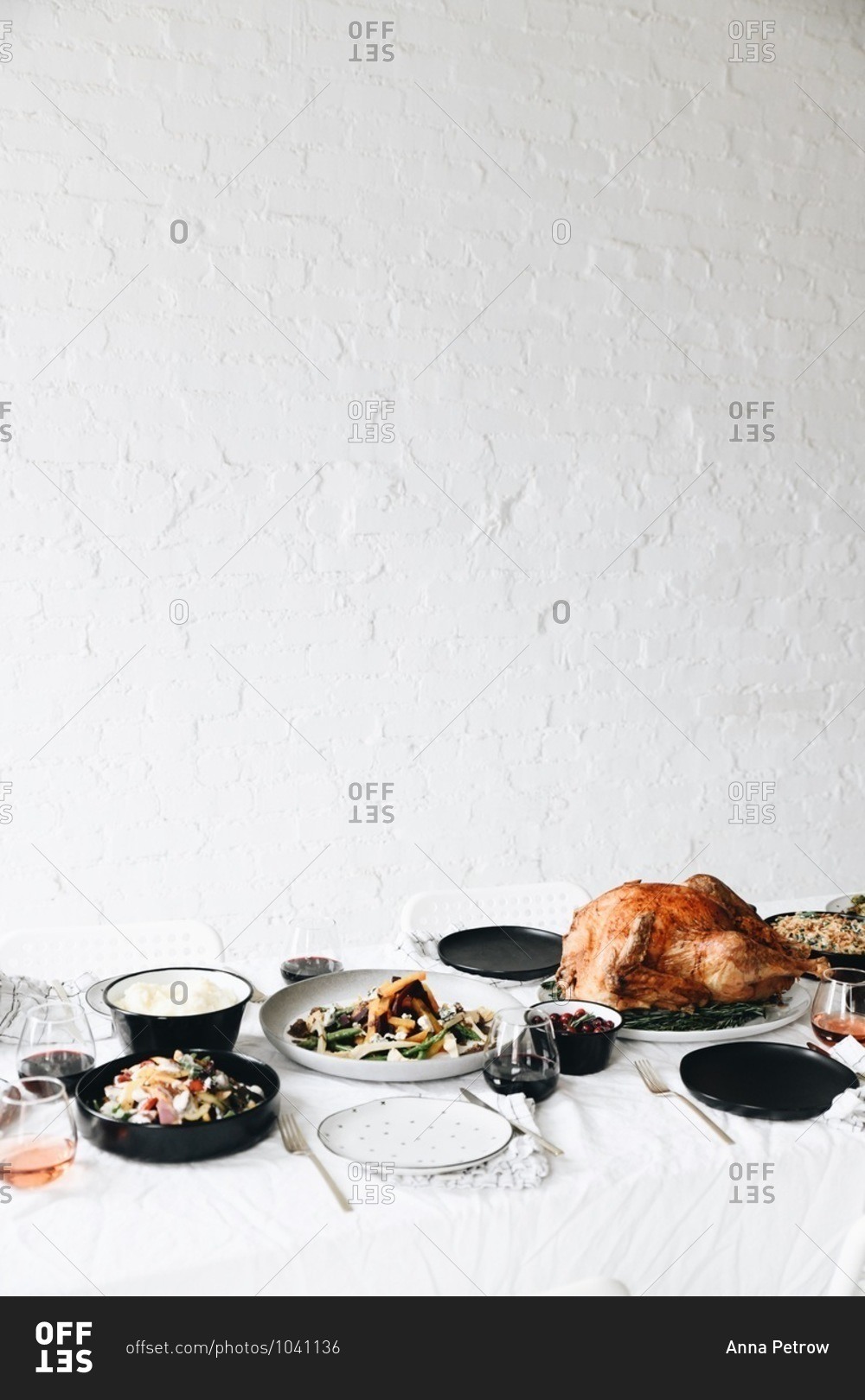 Traditional Thanksgiving dinner food served on a table in front of white texture wall