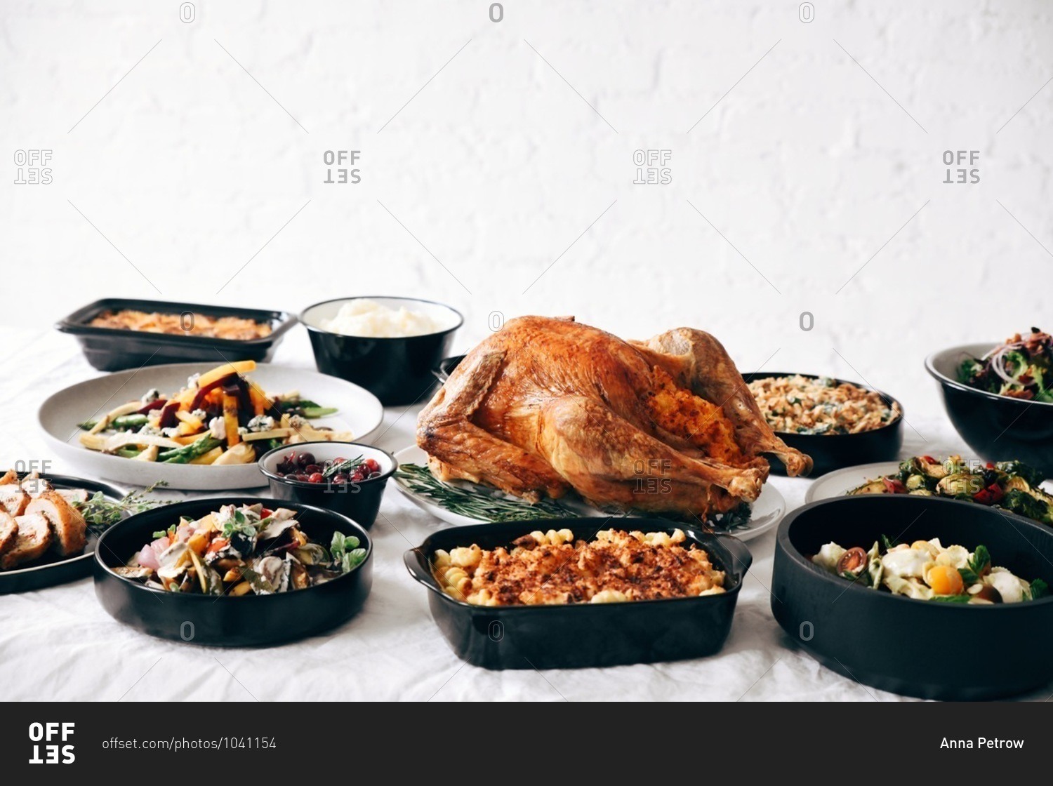 A traditional Thanksgiving dinner served on a table in front of white texture wall