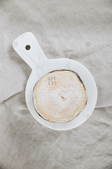 Overhead view of soft white bloomy rind cheese wheel on marble