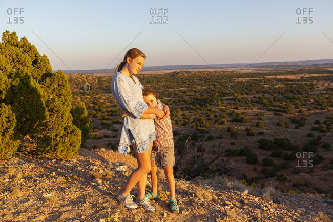 Teenage girl embracing her younger brother in the Galisteo Basin, Santa Fe