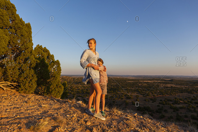 Teenage girl embracing her younger brother in the Galisteo Basin, Santa Fe