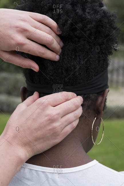 Therapist touching a client's head and neck, in an outdoor therapy session