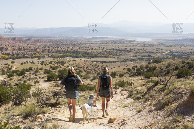 Three people, family hiking on a trail through a protected canyon landscape