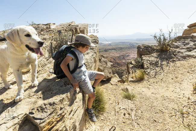 young boy hiking with his dog on Chimney Rock trail, through a protected canyon landscape