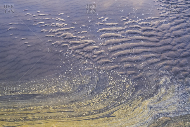 Ocean water and ripple patterns in the sand at low tide.