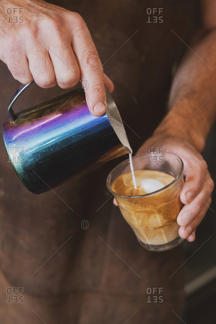 Close up of barista pouring a cafe latte.