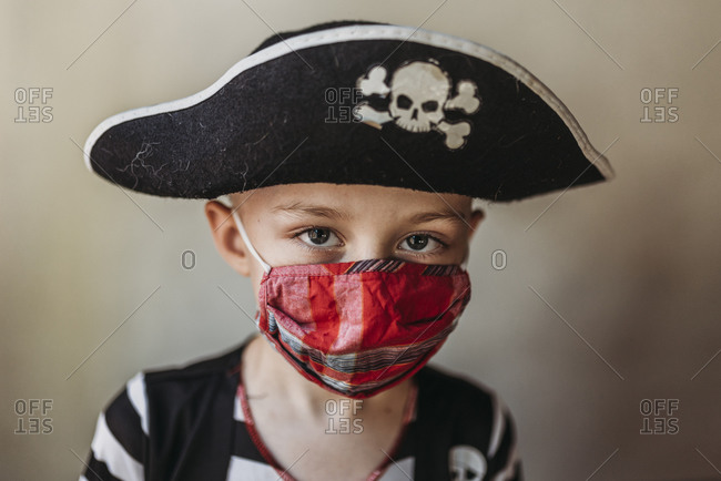 Portrait of school age young boy dressed as pirate with face mask on