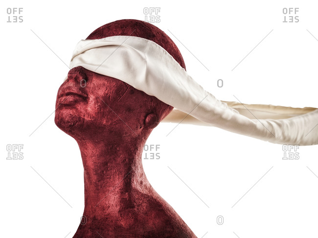 Red mannequin head with scarf on the eyes