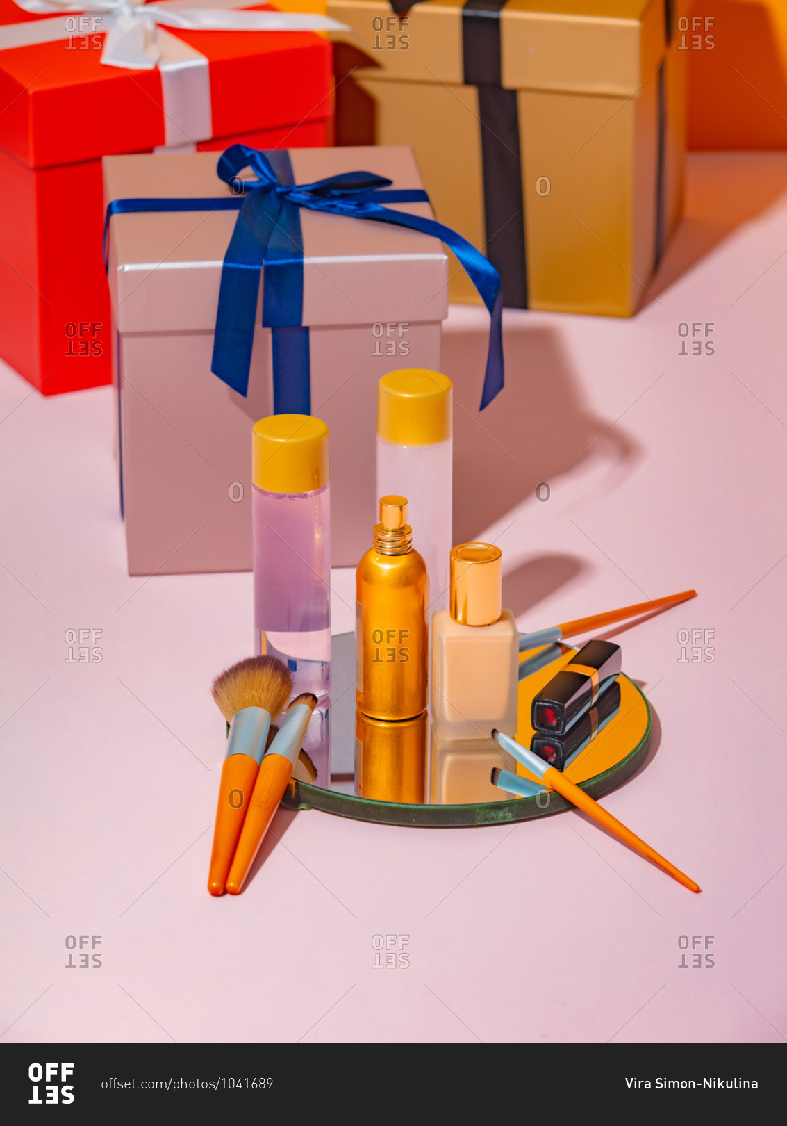 Cosmetics on a mirror beside gift boxes