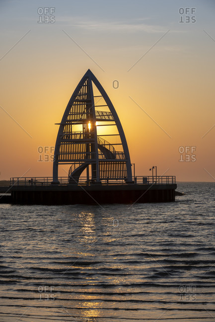 Germany, Lower Saxony, East Frisia, Juist, sunrise mood at the port entrance with the sea mark (17 m high steel structure).