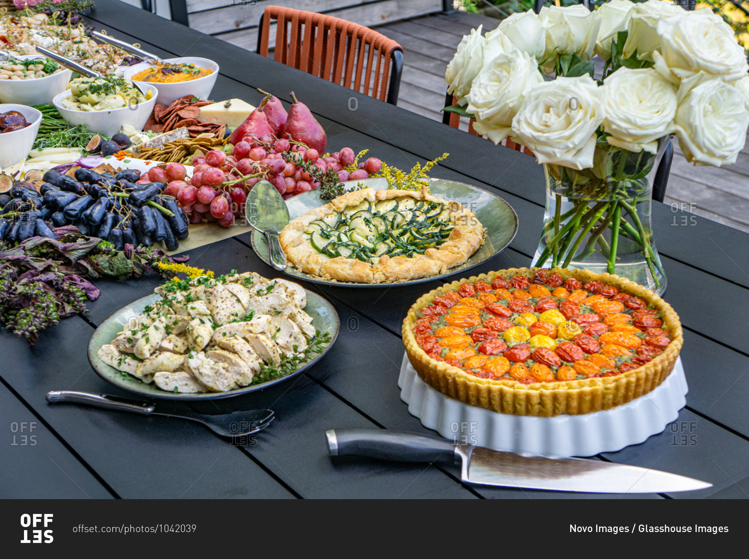 Grazing Board with Charcuterie, Tarts, Fruits and Vegetables on Table in Outdoor Setting