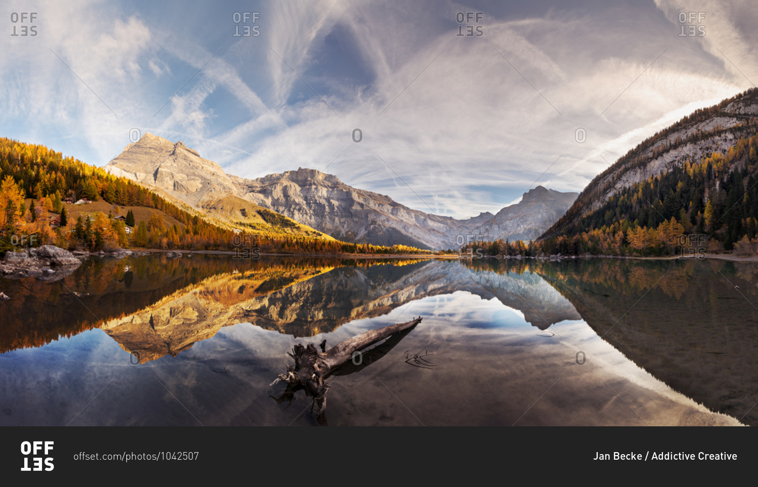 Spectacular scenery of lake with smooth surface reflecting amazing mountain range and sky