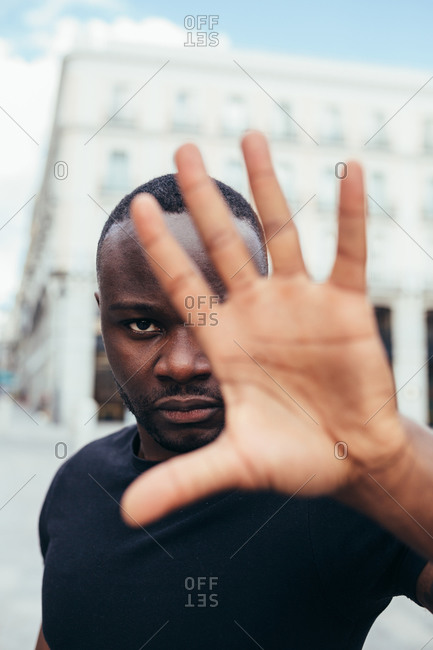 Man protesting at a rally for racial equality raising arms showing hand to camera. Black Lives Matter.