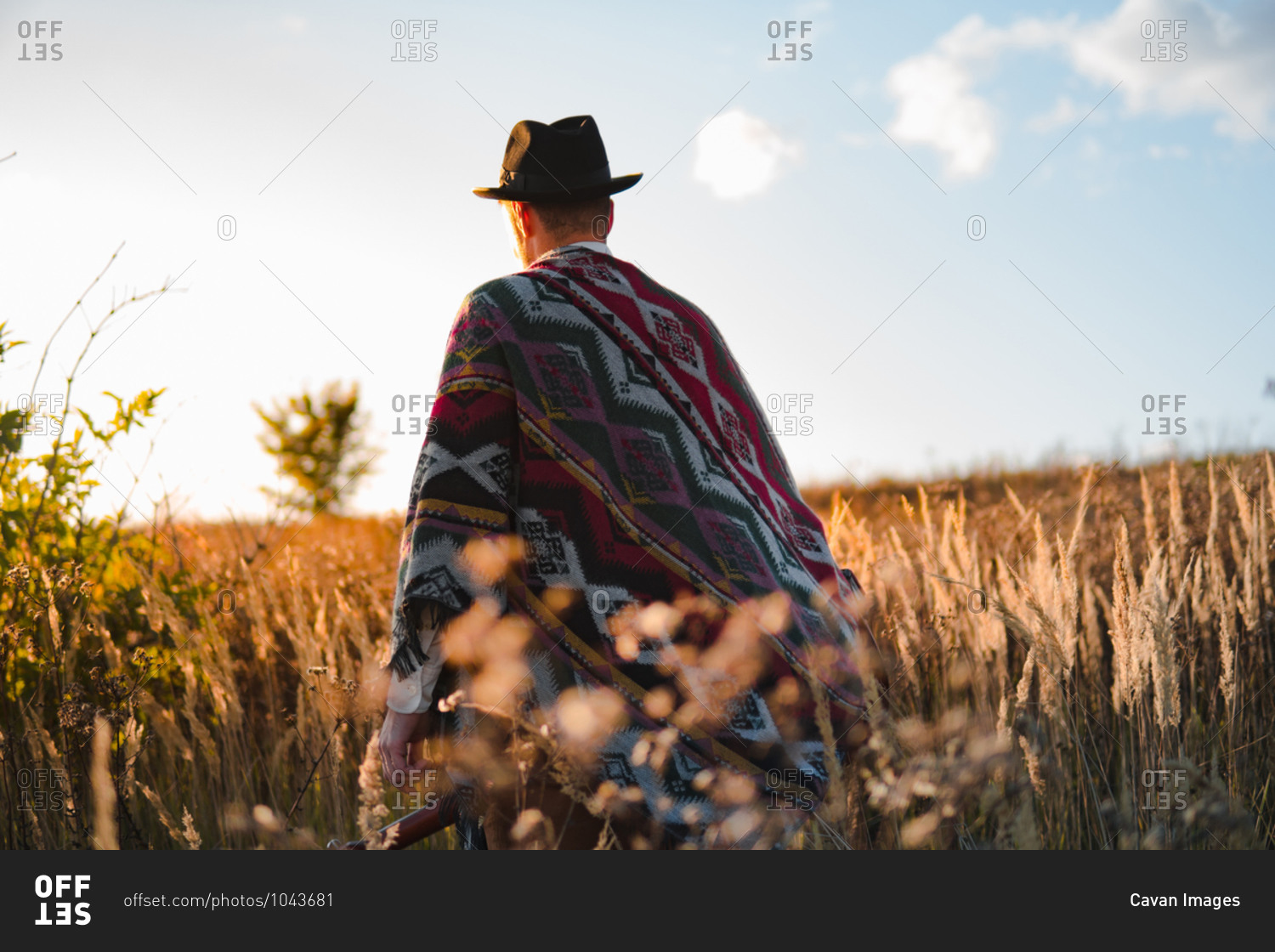 Man in poncho in a country field, atmospheric rural scene