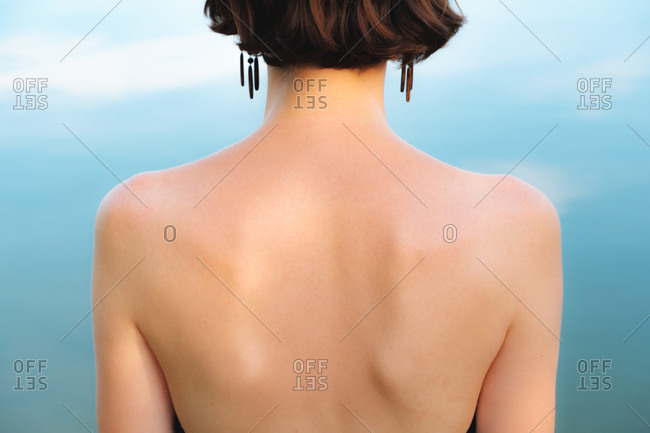 Back of a woman in natural blue backdrop.