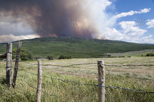 Landscape with smoke emitting from wildfire in background