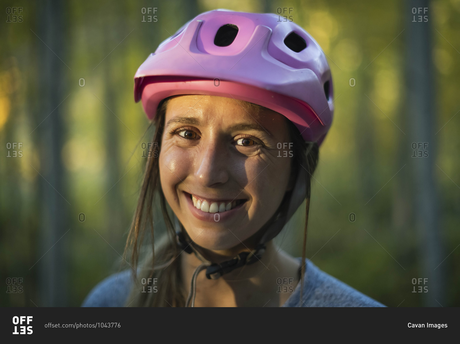 Close-up portrait of smiling young woman wearing cycling helmet