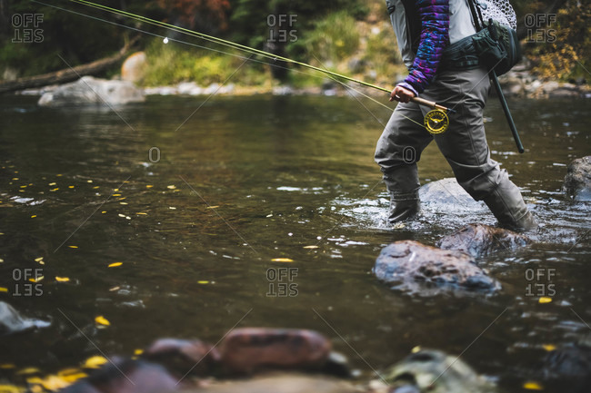 Midsection of woman fly fishing at Roaring Fork River during