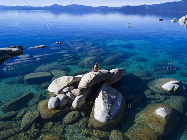 Woman looking at view while sitting on rock at Lake Tahoe
