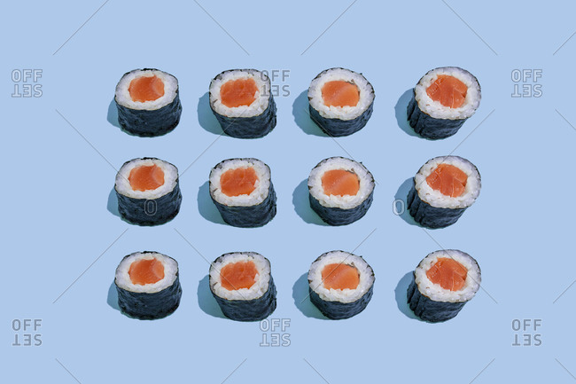 Salmond sushi makis pattern on blue background with shadows