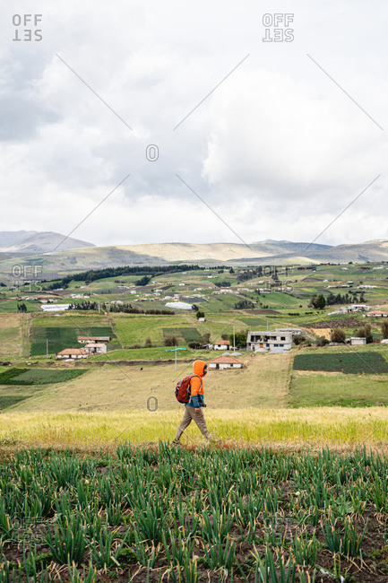 Young explorer walking in the Andes mountains with his equipment