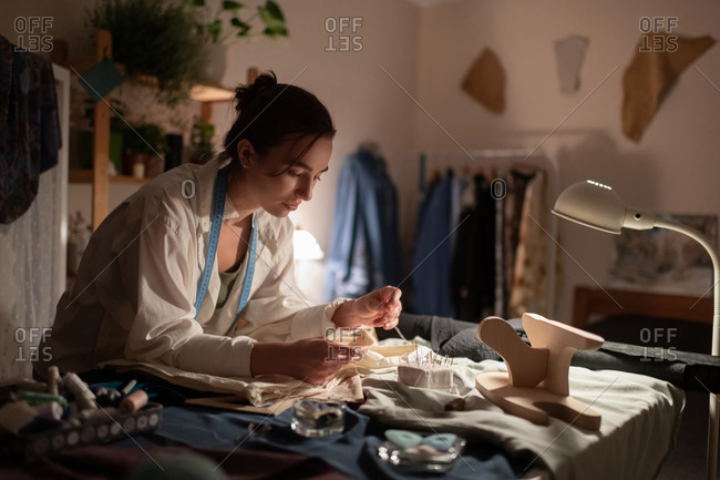 Female tailor working in evening