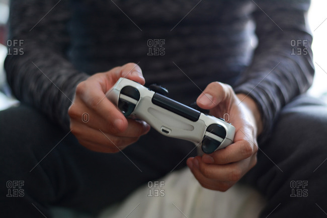 A man holding a game controller. A young man playing video games,