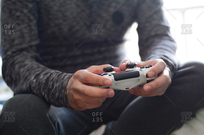 A man holding a game controller. A young man playing video games,
