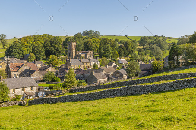 View of village church, cottages and dry stone walls, Hartington, Peak District National Park, Derbyshire, England, United Kingdom, Europe