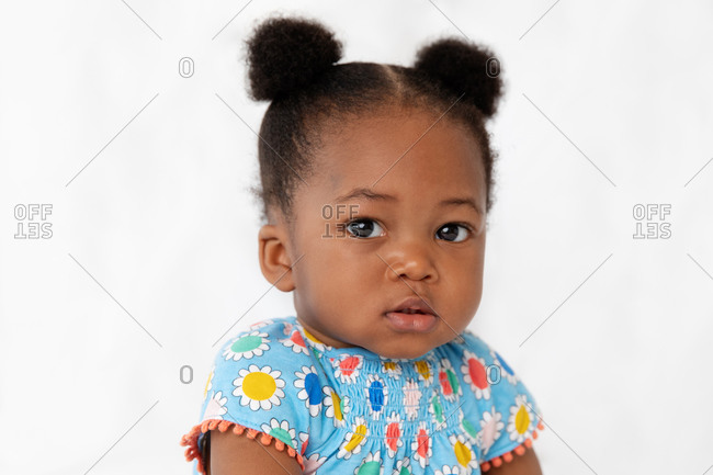 Close up of cute baby girl with hair buns stock photo - OFFSET