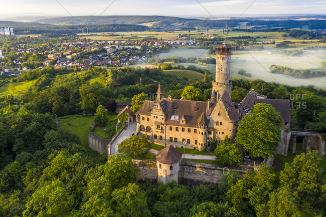 Germany- Bavaria- Bamberg- Helicopter view of Altenburg castle at foggy summer dawn