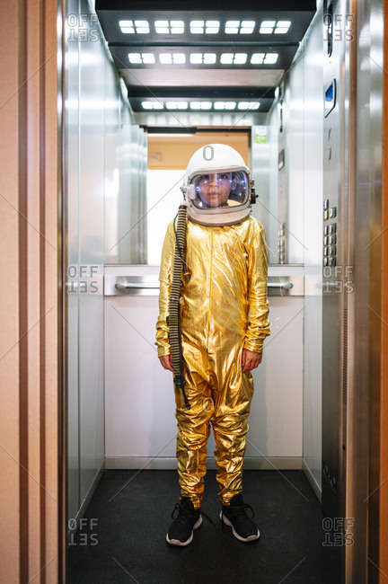 Boy wearing space suit standing in open elevator