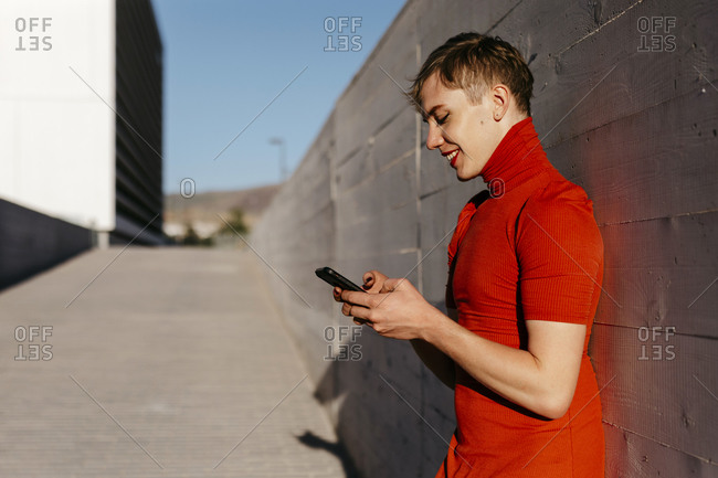 Happy non-binary female hipster standing on the road in city stock photo