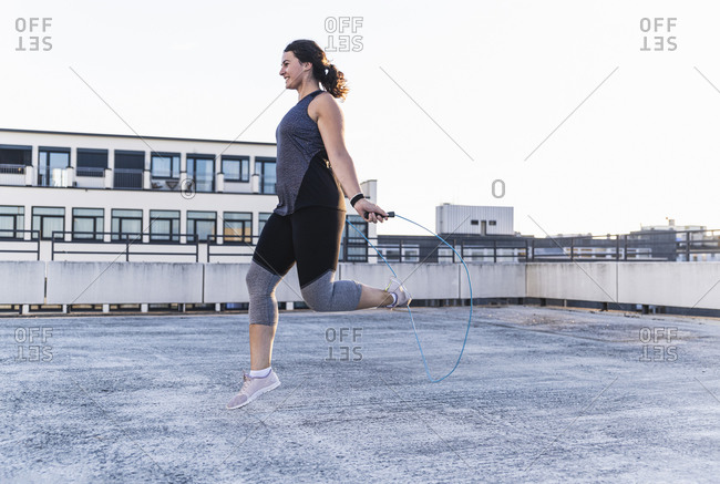 Unrecognizable Sportswoman Jumping Rope On A Bridge Stock Photo