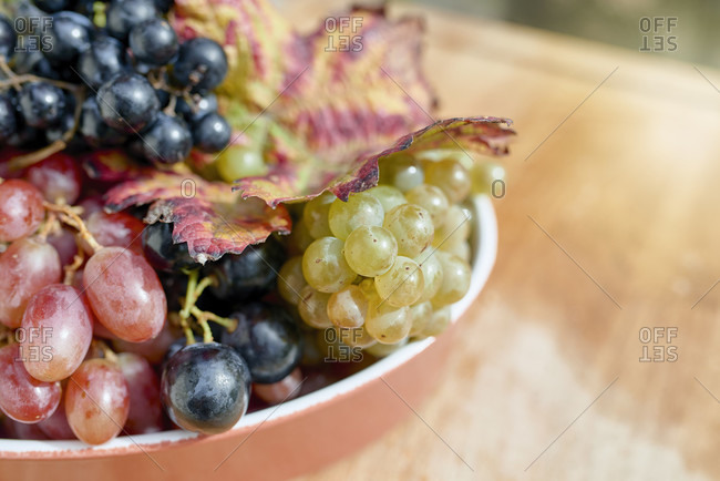 Red, white and light red grapes in a flat bowl