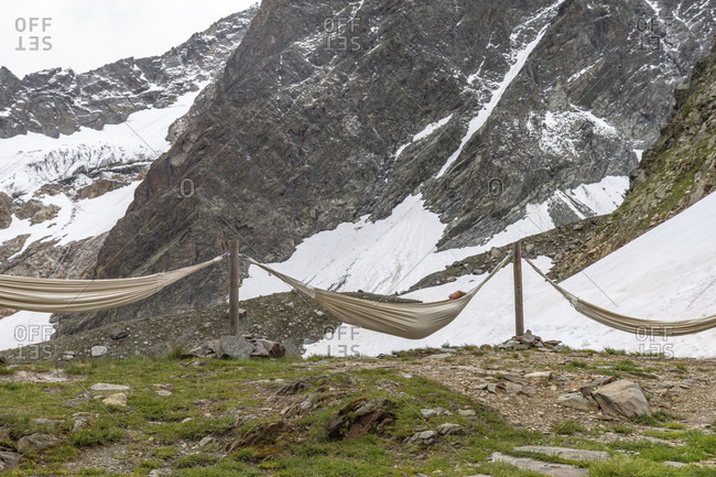 July 15, 2019: europe, austria, tyrol, otztal alps, pitztal, plangeross, mountain hiker relaxes in a hammock on the kaunergrathutte