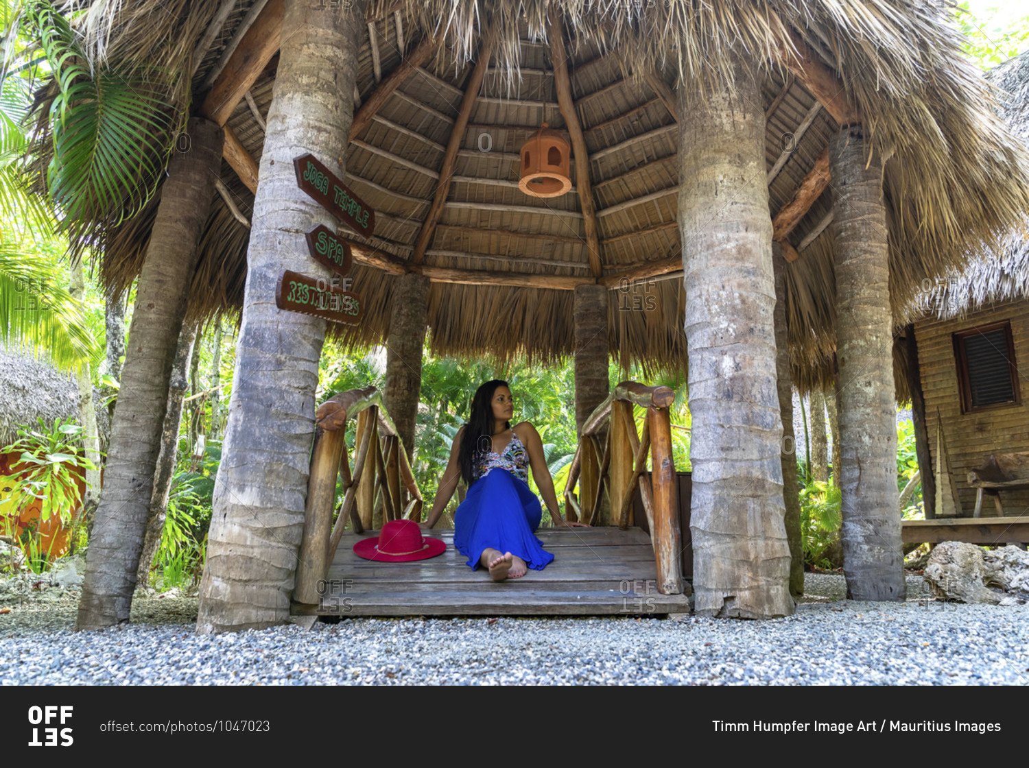 America, caribbean, greater antilles, dominican republic, cabarete, woman sitting on a small wooden bridge in the natura cabana boutique hotel & spa