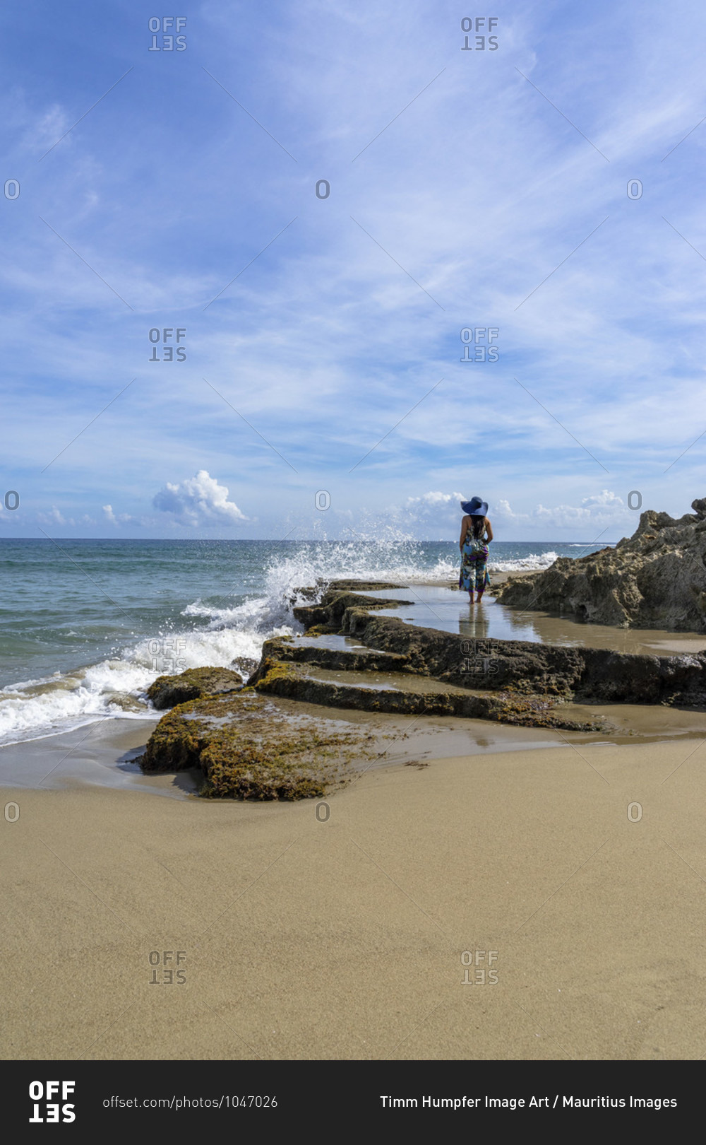 America, caribbean, greater antilles, dominican republic, cabarete, woman stands on a rock and looks out to sea