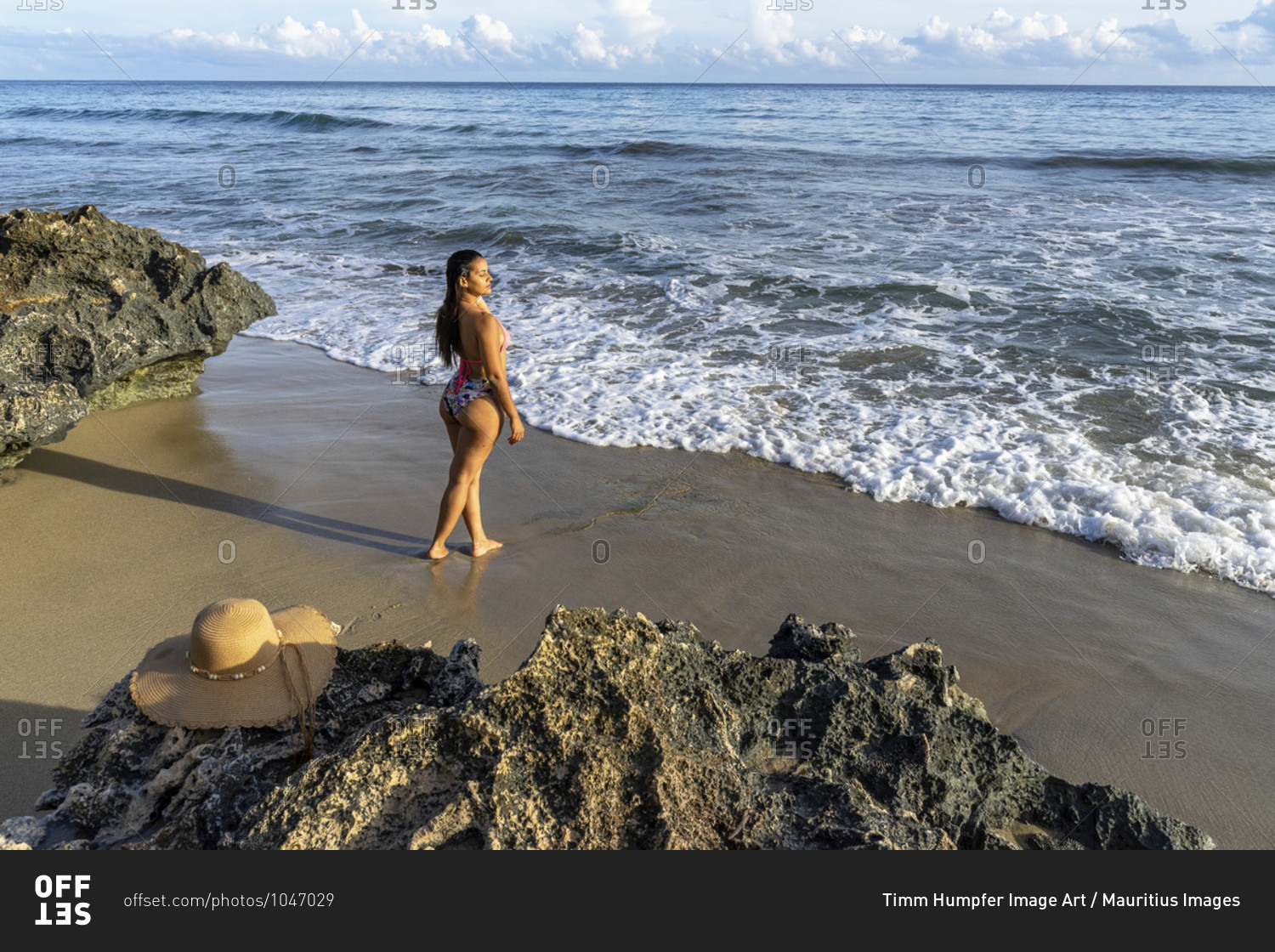 America, caribbean, greater antilles, dominican republic, cabarete, woman stands on the beach of the natura cabana boutique hotel & spa