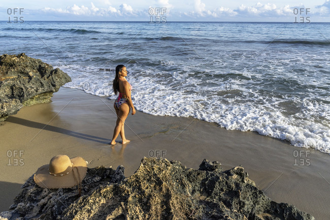 America, caribbean, greater antilles, dominican republic, cabarete, woman stands on the beach of the natura cabana boutique hotel & spa