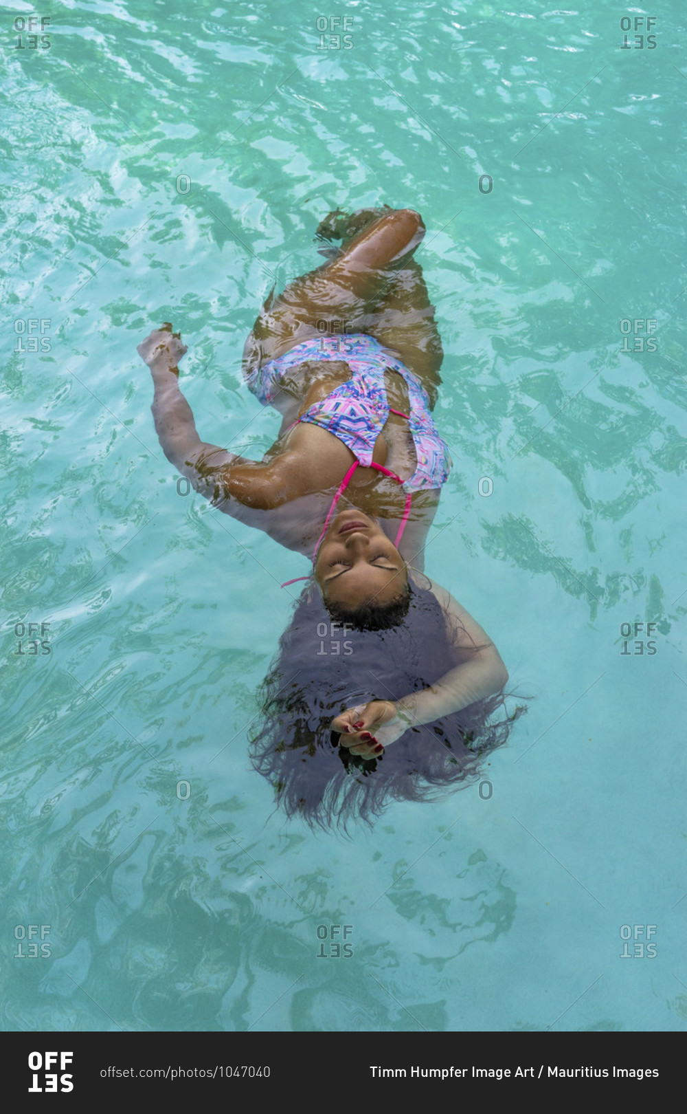 America, caribbean, greater antilles, dominican republic, cabarete, woman swims on her back in the pool of the natura cabana boutique hotel & spa