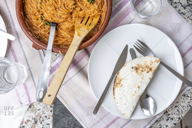Above photograph of a table served with vegetarian food with mexican-style noodle pasta accompanied by beans and quesadillas